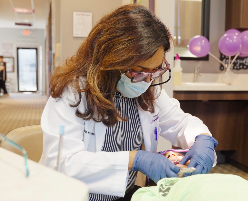 Dr. Sheela Kudchadker of Pearland Orthodontics in Texas examines a patient's teeth
