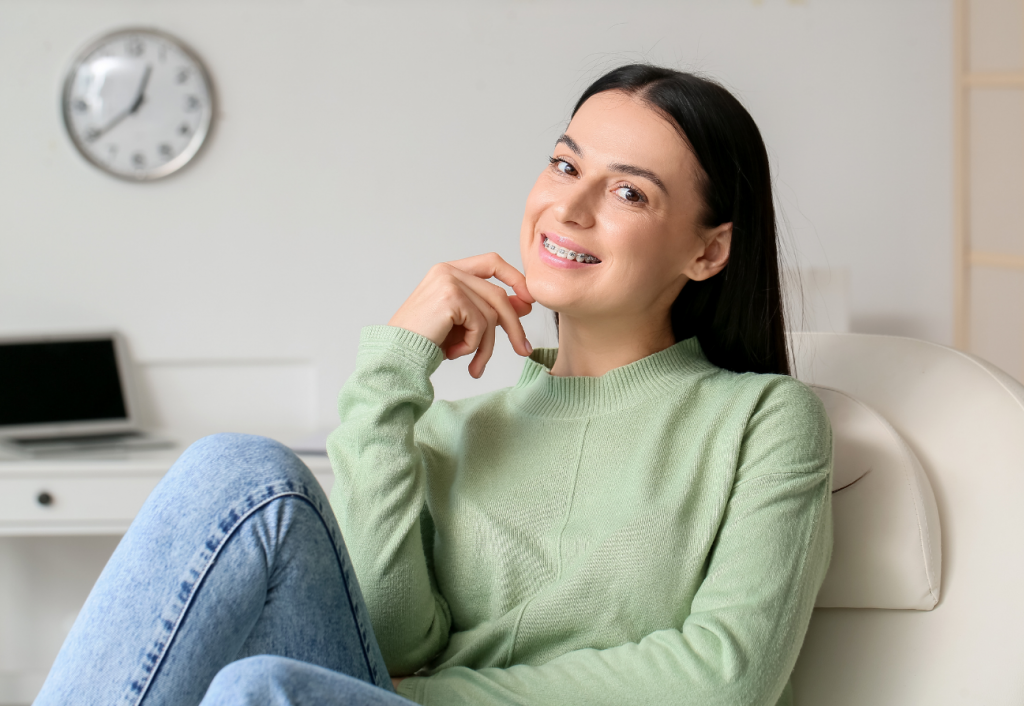 A smiling woman with braces sitting in an office