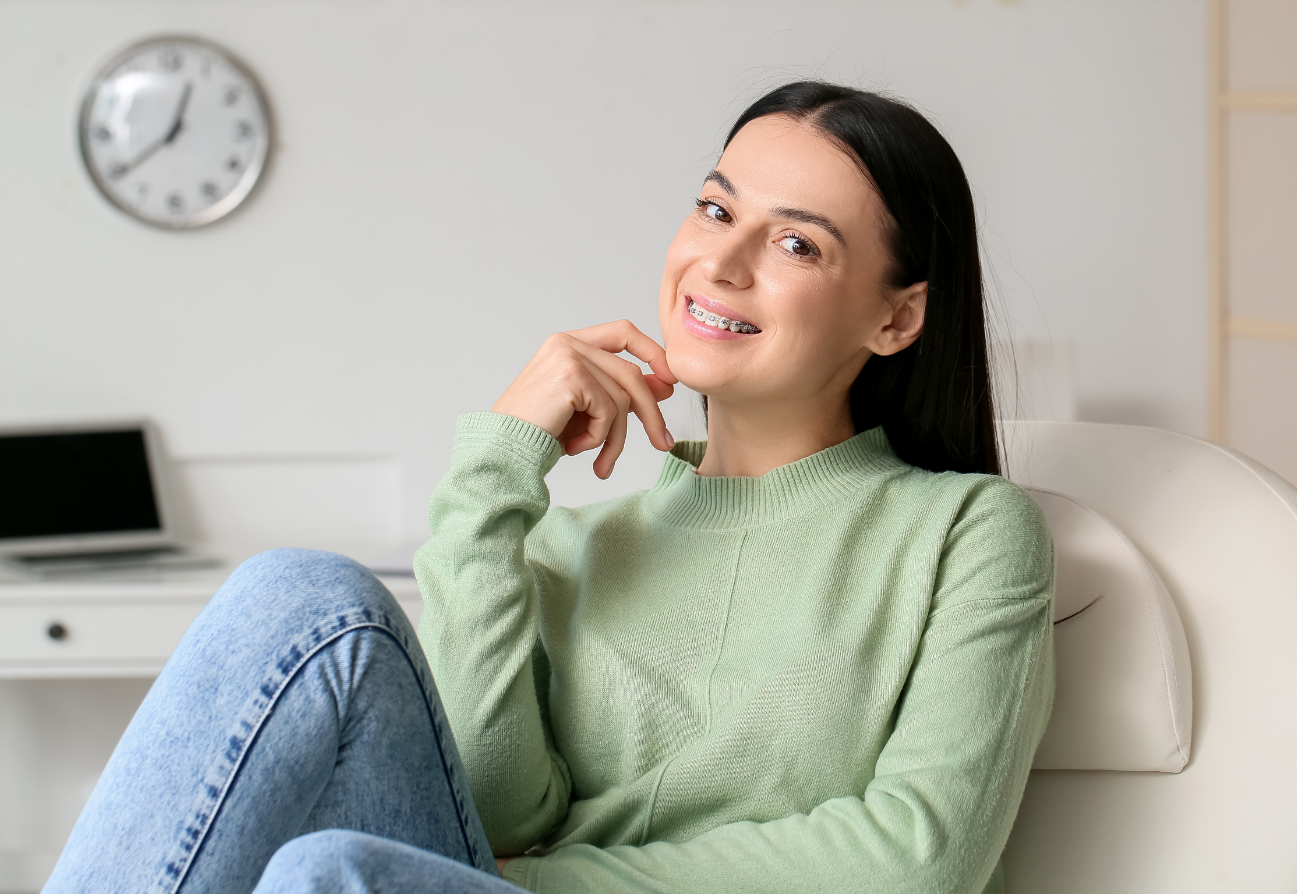 A smiling woman with braces sitting in an office