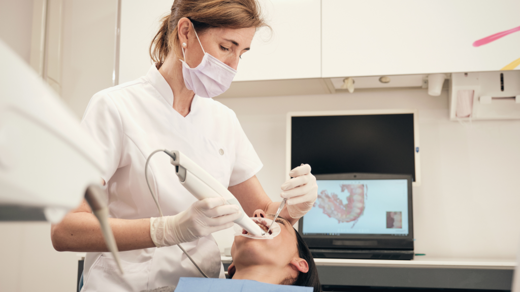 A female orthodontist using a digital scanner to get images of the patients mouth