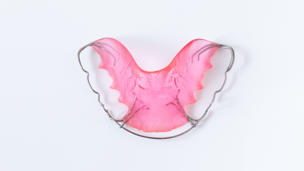 A pink Hawley retainer sitting on a white table