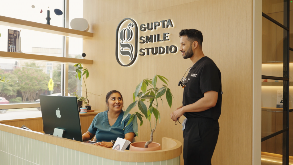 An orthodontist and his receptionist at the front desk of Gupta Smile Studio in Dallas Texas