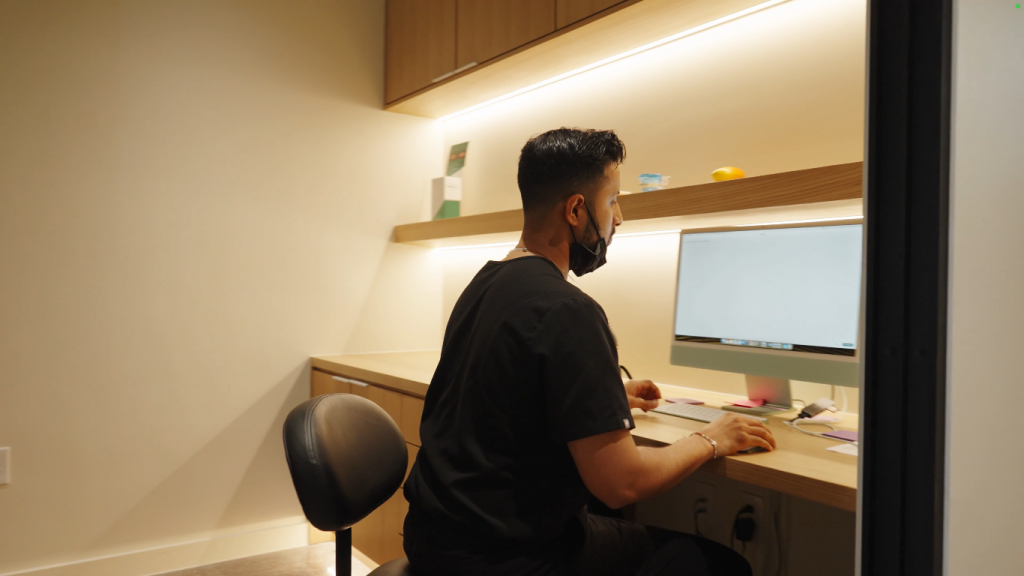 A young orthodontist works at his computer